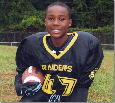 Carl Joseph Walker-Hoove age 11. He is wearing a football uniform, holding a helmet and smiling. 